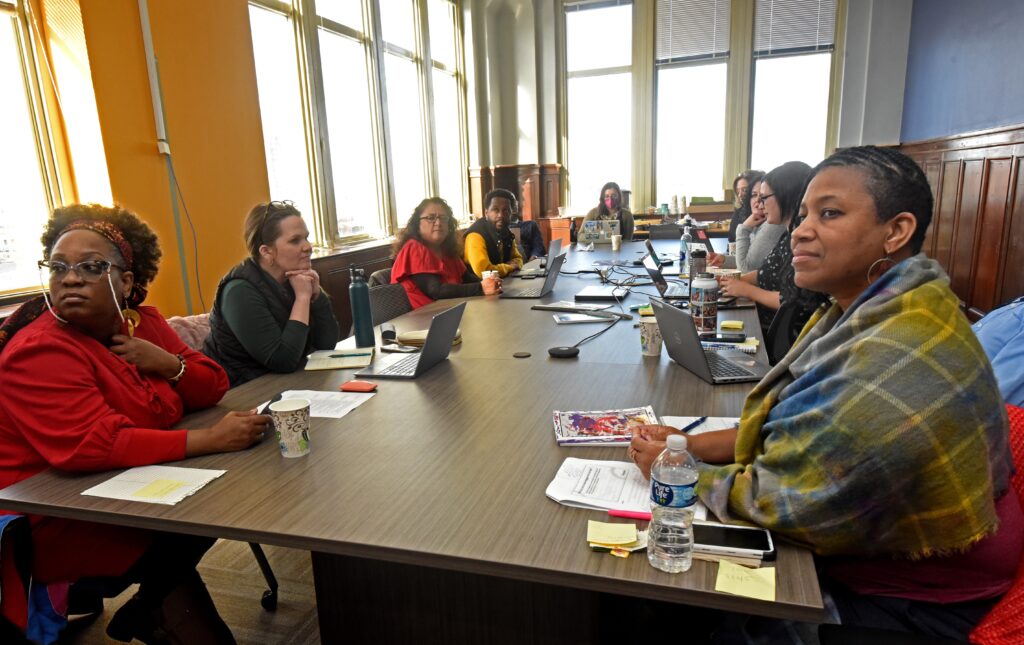 Members of the INSPIRE team sit around a conference table together during a meeting.